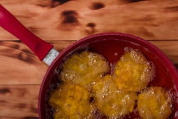 Fritters frying in a red pan